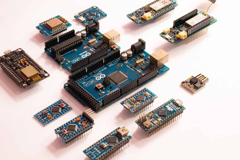 Various Arduino and microcontroller boards are displayed on a white surface, including an Arduino Mega and several smaller boards, showcasing different connection ports and configurations. Emphasizing E-waste disposal, these components offer a sustainable alternative when choosing to recycle computers or laptops.
