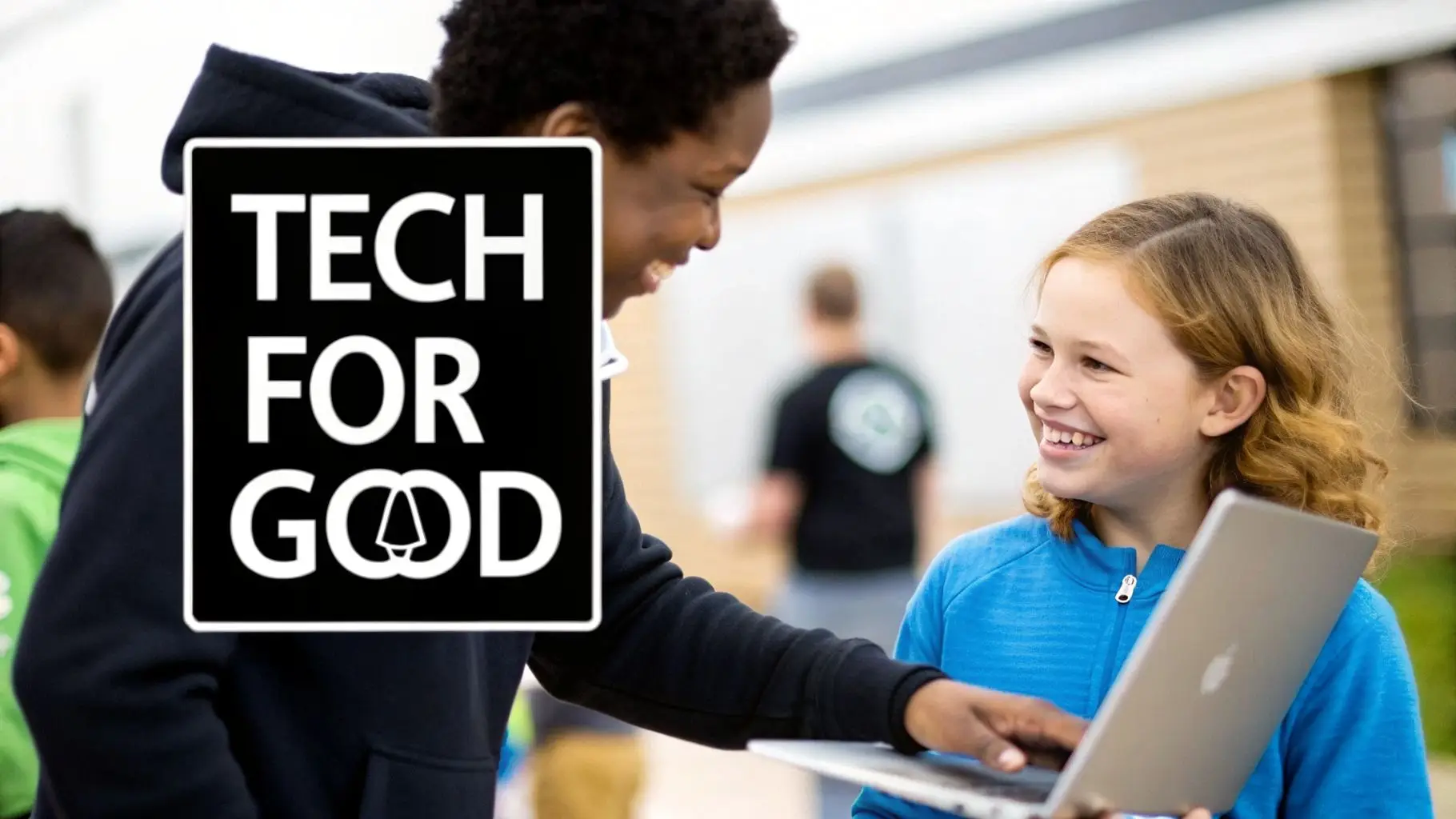Two smiling children, an older boy and a younger girl, collaborate on a laptop, with a 'TECH FOR GOOD' sign visible.
