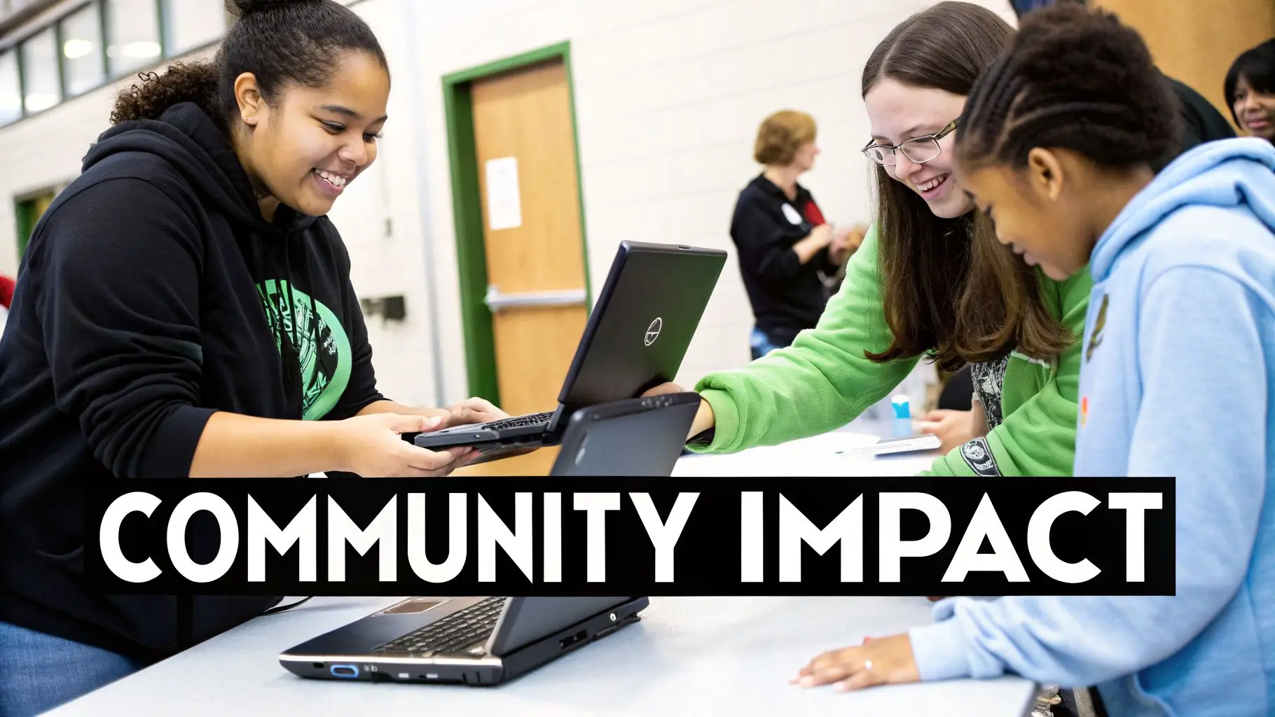 Smiling young people using laptops together at a table, learning and collaborating.