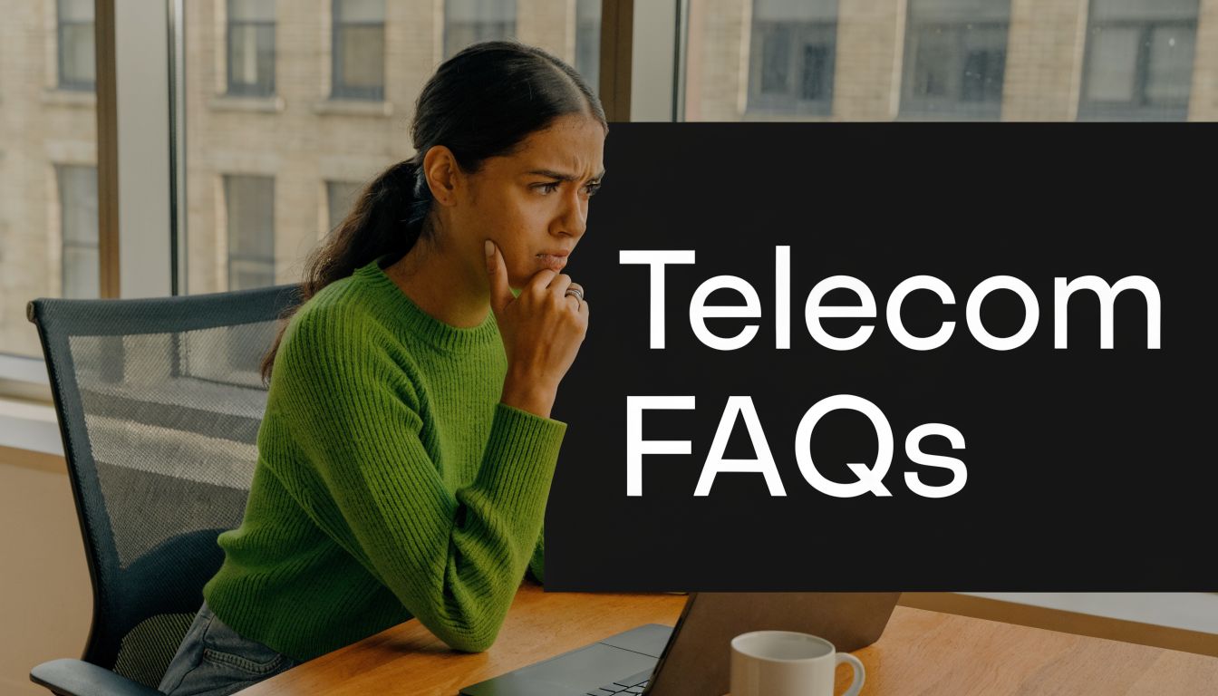 A focused woman working at her laptop while analyzing telecom FAQs in a professional office setting.