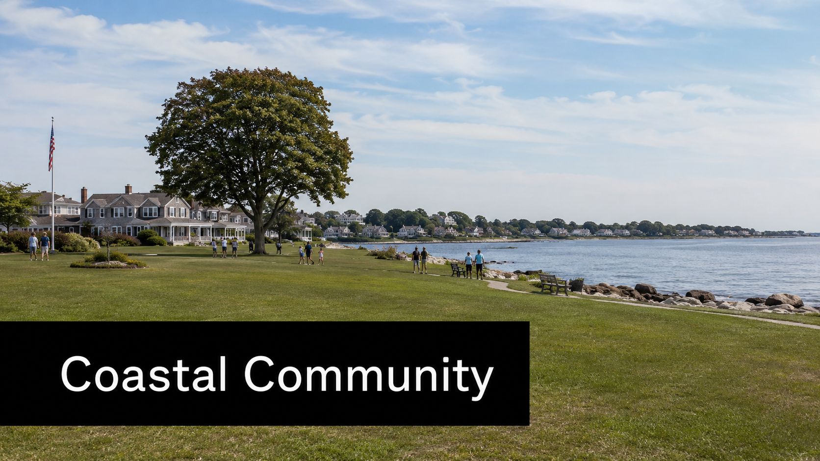 A scenic view of a coastal community with houses, a large tree, and people enjoying the lawn.
